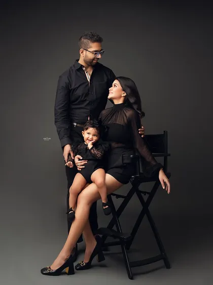 Squad goals! This family portrait is all about modern style and fun. The coordinated black outfits and the little one's happy expression make for a stunning and memorable family photo.