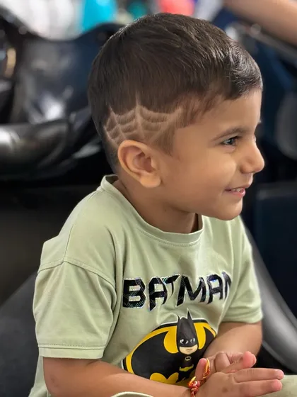 Haircuts for kids should be fun, not scary. I love getting creative with designs, like this cool spider-web pattern etched into a neat haircut for this little superhero.