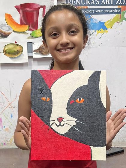 A happy student with her completed cat canvas. The bold red background makes the black and white cat stand out beautifully.