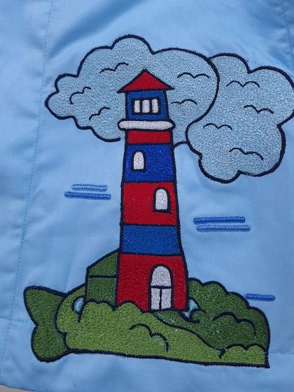 This is a close-up of a lighthouse embroidery from a boat-themed saya kurta I made for a child's first birthday.