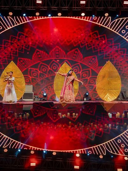 The stage design for our 'Chandni Ratein' theme featured a stunning mandala graphic on the LED screen. The bride's performance, with dancers holding leaf-shaped props, created a beautiful, layered visual.