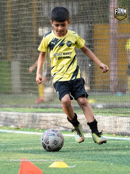 Close control dribbling is a fundamental skill. Here, a player practices maneuvering the ball through cones to improve his touch.