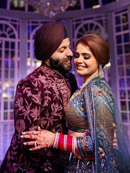 Sahib and Muskan in a loving embrace, showcasing their richly detailed and colorful sangeet outfits. We pay close attention to capturing the beauty of Indian couture.