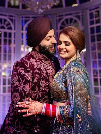Sahib and Muskan in a loving embrace, showcasing their richly detailed and colorful sangeet outfits. We pay close attention to capturing the beauty of Indian couture.