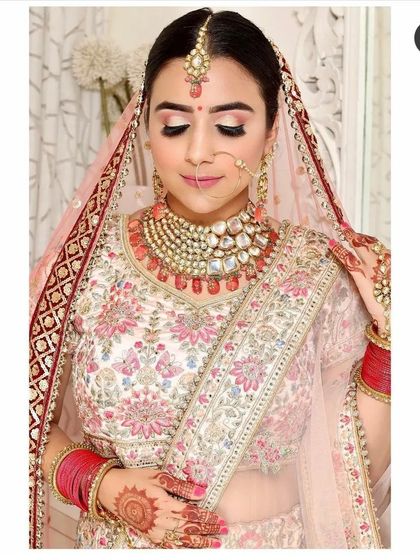 A detailed view of the intricate floral threadwork on this pastel bridal lehenga. Renting allows you to wear high-quality, designer-style outfits without the investment.