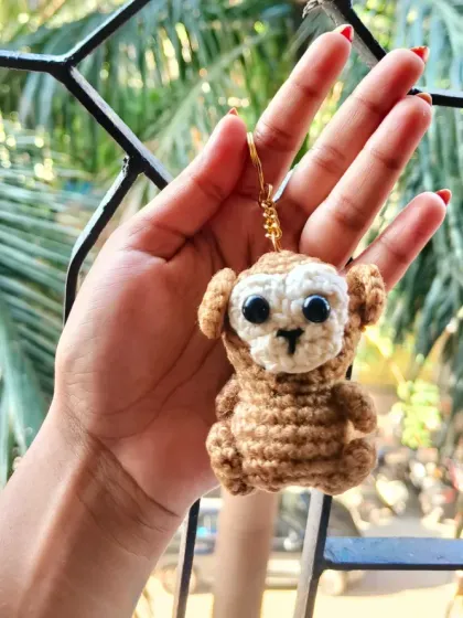 Just the monkey keychain, held up to show its full body and sweet expression. This handmade animal charm is a favorite for all ages.