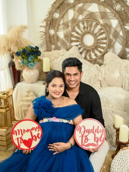 Announcing their journey to parenthood with adorable signs, this couple's joy is infectious in their bright and happy studio maternity session.
