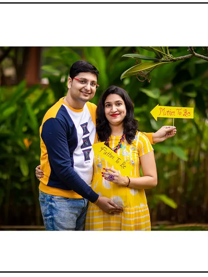 A fun and casual shot with the couple holding "Mother to be" and "Father to be" arrow signs.