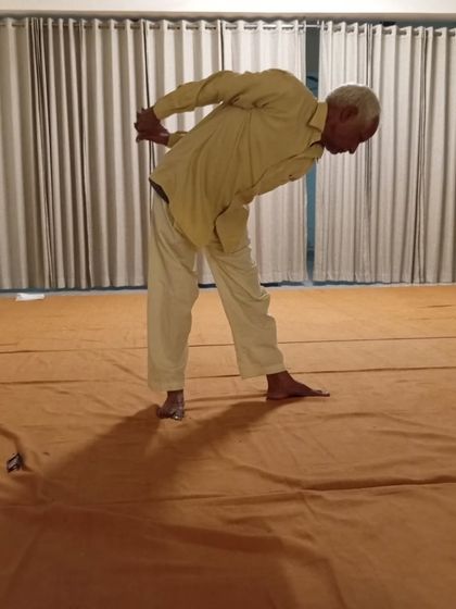 A standing posture that works on balance and spinal flexibility, practiced with grace.