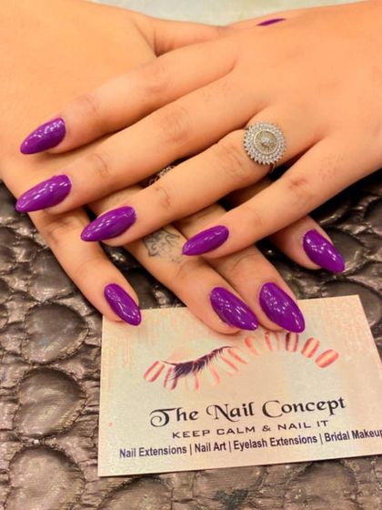A classic and chic set of almond-shaped nails in a solid, glossy dark purple. This sophisticated color is always a stylish choice.