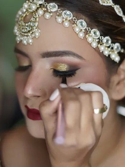 A behind-the-scenes shot of creating the perfect winged liner for a bold, golden-eye bridal look. Precision is key for such intricate work.