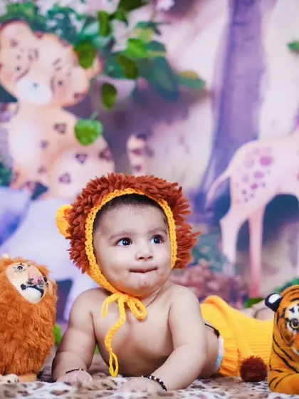 This little lion is posing with his plush tiger and lion friends.