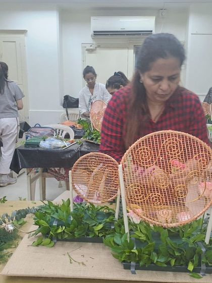 A student adds flowers to her Diwali centerpiece. Our workshops are designed to be completely hands-on, allowing you to learn and practice techniques with real materials in a supportive environment.