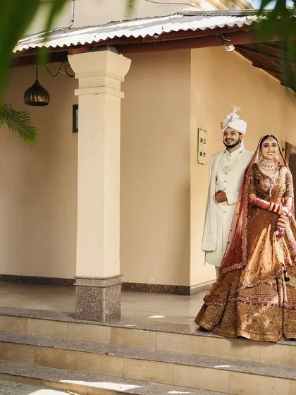 A classic wedding day portrait. The couple stands together, perfectly framed, marking the beginning of their new life. This is a timeless shot that captures the elegance and significance of the day.
