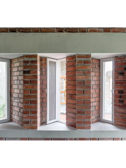 A detail of the skewed windows on the eastern and western facades of the ASA office. This angular placement is a specific passive design strategy to cut the harsh glare of the sun while still allowing for daylight and fresh air.