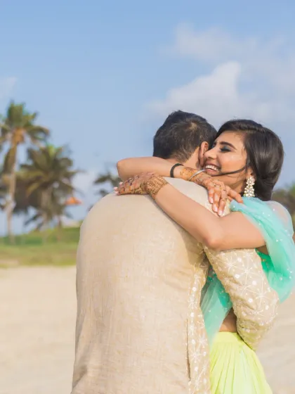 A candid and heartwarming hug on the beach, capturing a moment of genuine laughter and connection.