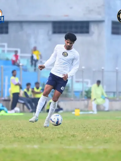 A player dribbles in open space, looking to build an attack from deep.