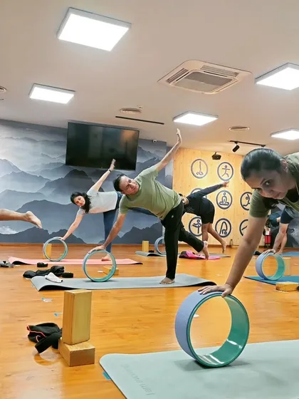 A close-up of students exploring Ardha Chandrasana (Half Moon Pose) with the support of yoga wheels. This demonstrates how we adapt poses to make them accessible and effective.