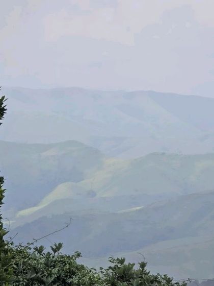 The vast, misty landscape as seen from the Kurinjal trek, with layers of hills fading into the distance.