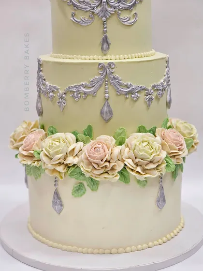 A close-up of the beautiful, hand-piped pastel buttercream roses on the vintage engagement cake.
