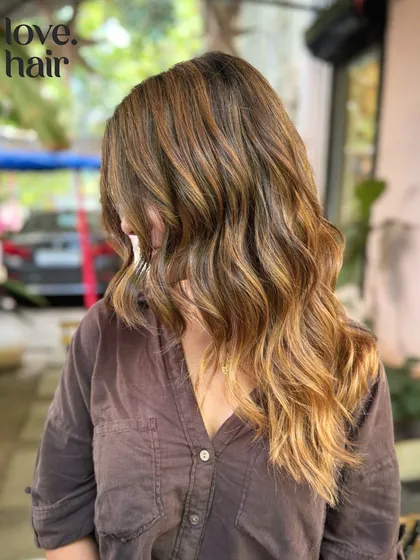 Molten lava hair. A fiery and warm bronde balayage with caramel and golden tones that look like flowing lava.