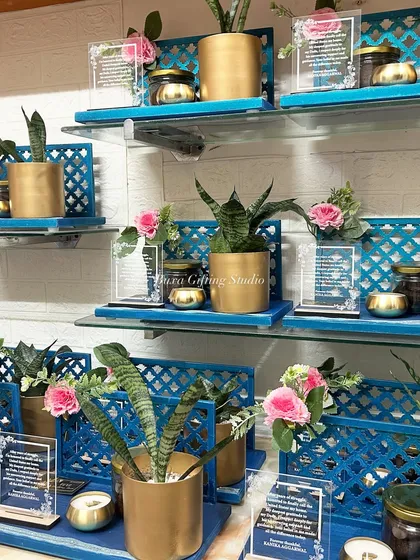 A display of the Green Card celebration platters, showing the beautiful combination of the blue jaali design, golden planters, and pink floral accents.