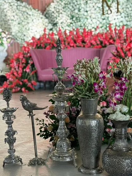 A collection of ornate silver props available for rent, including lamps, vases, and bird figures.