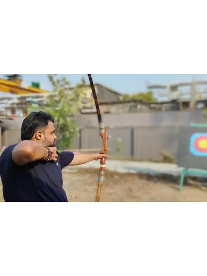 An adult student lines up his shot, showing the focus that archery helps to develop.