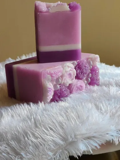 A lavender shea butter soap with intricate floral details on the side.