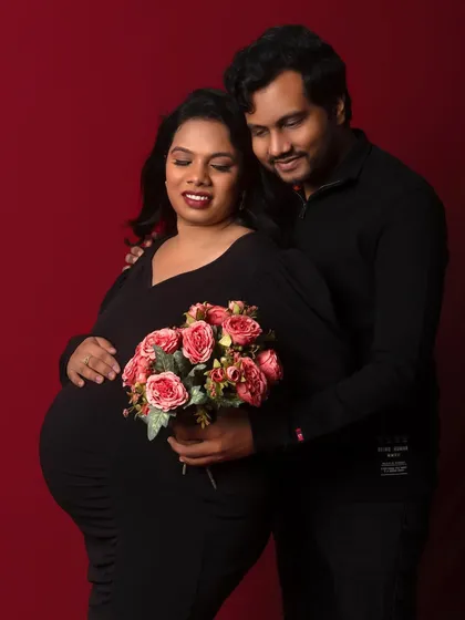 A classic and romantic portrait against a rich red backdrop. The flowers add a soft and beautiful touch.
