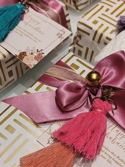 A close-up of the gift wrapping shows the detail of the layered tassels and the satin bow. These small touches are what make a gift feel curated and special.