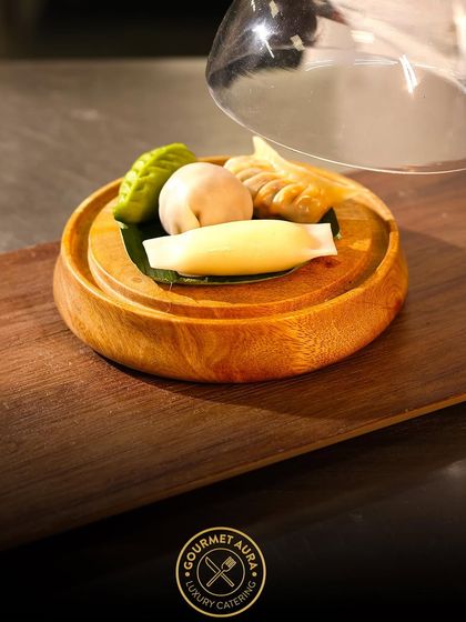 An assortment of delicate dim sum, including har gow and shumai, presented under a glass cloche for a touch of drama and elegance.