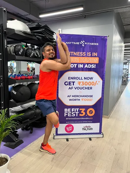 A smiling member holds the Eagle Pose, showing that challenges can be fun and rewarding.