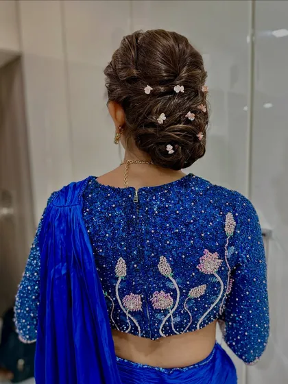 An elegant low bun decorated with small, scattered flowers. This hairstyle is sophisticated and perfect for a modern bride.