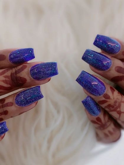 A close-up of the vibrant blue glitter nails.