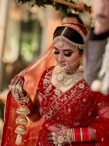 A beautiful moment of the bride adjusting her veil. Her makeup, with its focus on defined eyes and a radiant base, is designed to look perfect from every angle.