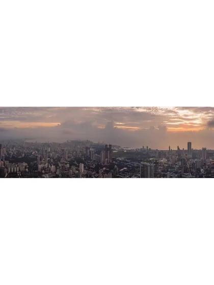 A wide panoramic shot of Mumbai, capturing the entire cityscape from a high vantage point under a cloudy sky.