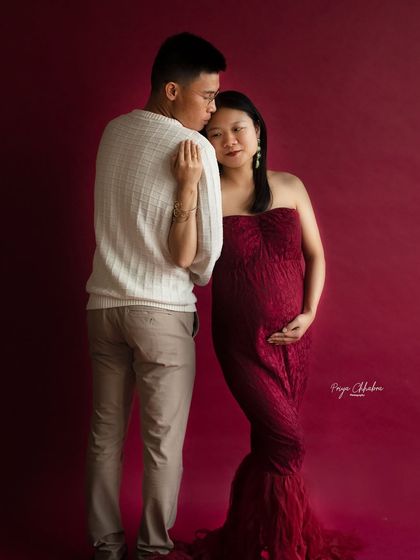 A tender moment from a studio session. The deep red gown adds a touch of richness and passion to this classic couple's pose.