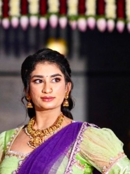 A vibrant and stylish half saree in lime green and royal purple. This unique color combination and the puff sleeve blouse make it a perfect outfit for a festive occasion or a friend's wedding.