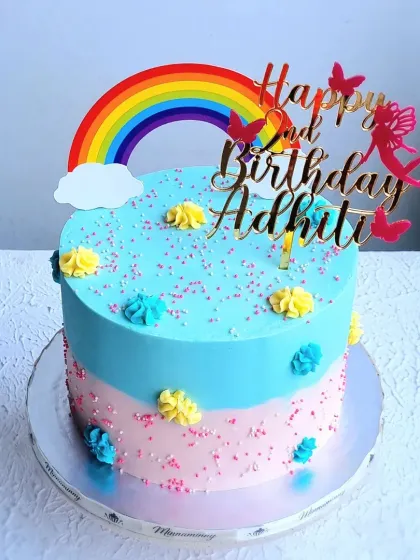 A simple and sweet rainbow-themed cake with a two-tone buttercream design. This is a great example of how color blocking with buttercream can create a lovely effect.