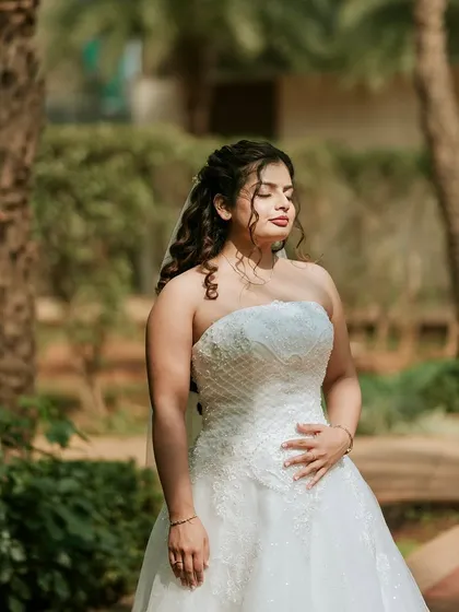 A serene outdoor portrait. The soft light and natural background highlight the timeless beauty of the bride and her classic look.