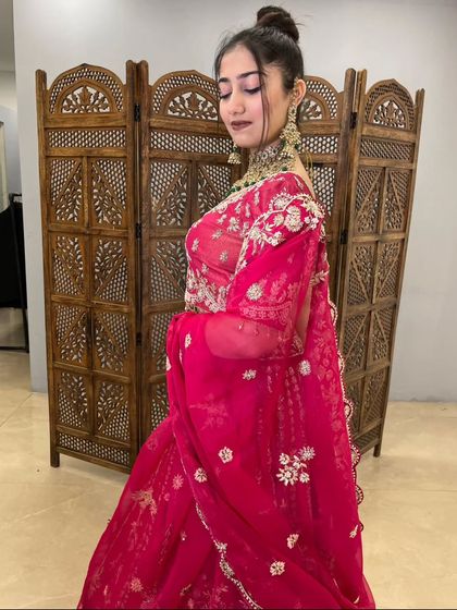 The elegant drape of the dupatta on this pink bridal lehenga. The soft net fabric is adorned with matching embroidery, completing the royal look.