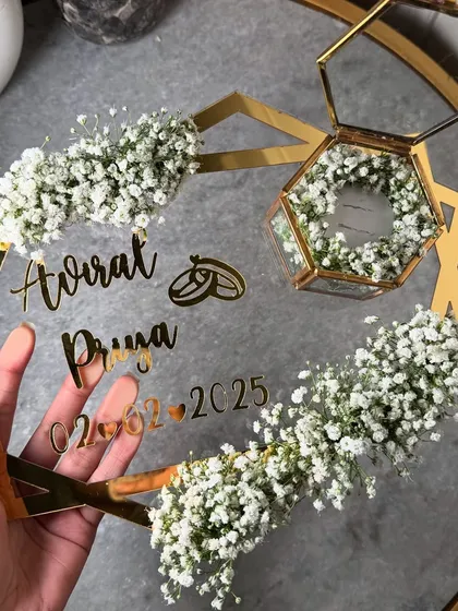 For a modern and minimalist aesthetic, this "pinteresty" design is a perfect choice. It features a clear acrylic hexagonal frame decorated with delicate baby's breath, a hexagonal glass ring box, and personalized gold lettering for the couple's names and date.