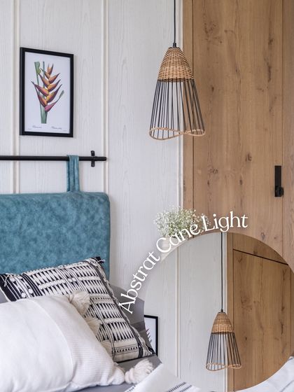 This abstract cane pendant light serves as a functional sculpture in the bedroom. Its unique shape and mix of natural and black materials add visual interest and complement the room's modern, eclectic vibe.