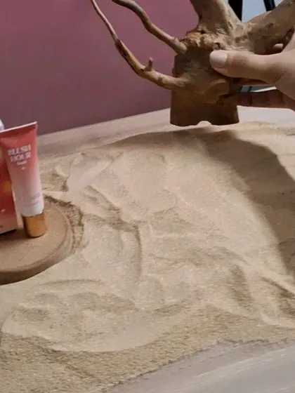 Styling a desert scene with sand and driftwood for a "Dusk" themed product.
