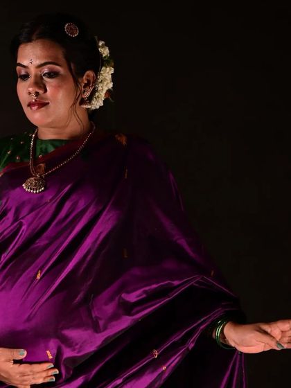 Capturing the serene joy of motherhood. This is a traditional maternity look, featuring a beautiful purple silk saree and soft, elegant makeup.