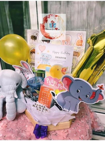 An adorable animal-themed birthday hamper for a little one. This custom gift includes a plush elephant, animal-themed puzzles and books, and a fun foil balloon to make their day extra special.