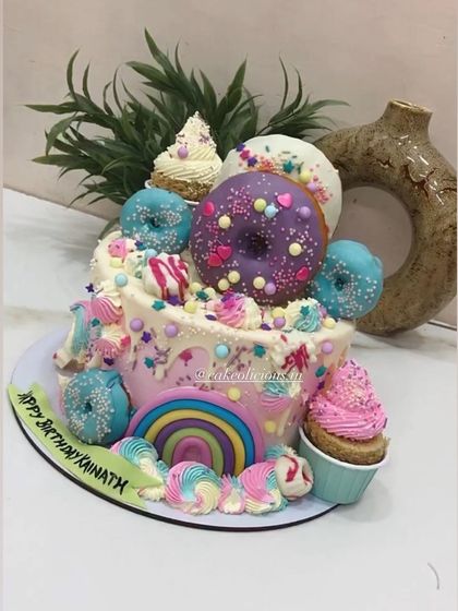 A candyland cake straight out of a dream. Every single decoration on this cake, from the colorful donuts to the candies and rainbow, is made in-house to ensure the best quality and taste.
