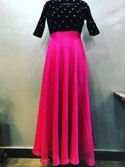 This is a custom two-piece dress. It has a black velvet top with gold polka dots and a flowing pink chiffon skirt.