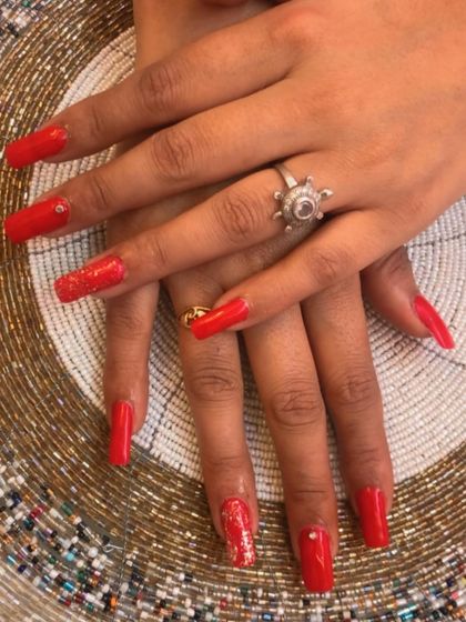 The length and shape of these square red nails add to their dramatic and glamorous feel.